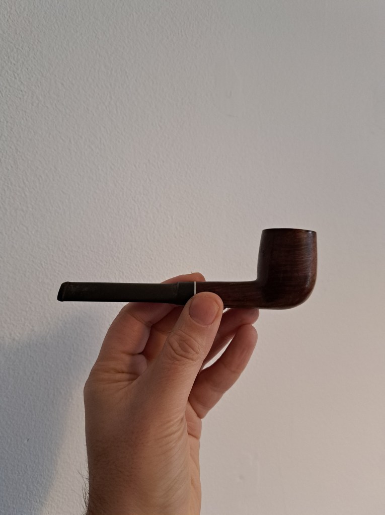 My hand holds my late father's pipe. Or one of them. 